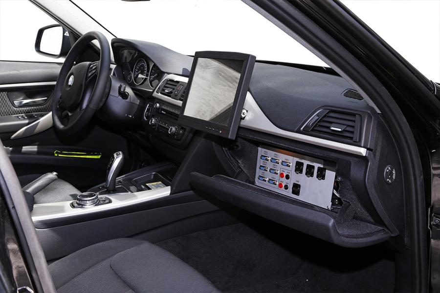 Das Innere der Fahrzeugkabine des Versuchsfahrzeugs VIKTOR mit diversen Anschlüssen für IT-Geräte und einem extra Monitor.